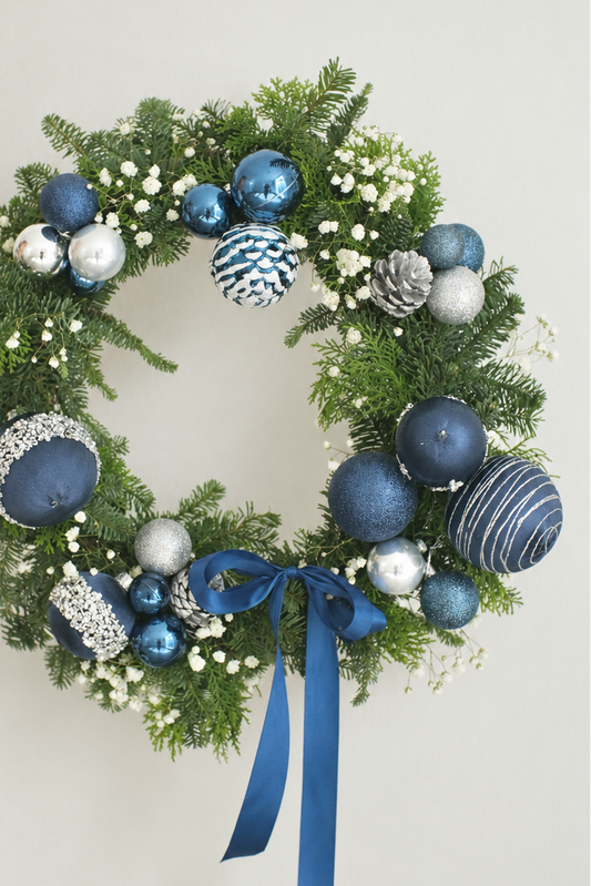 Fresh blue and silver Christmas wreath with baby's breath, silver pinecones and a navy satin bow