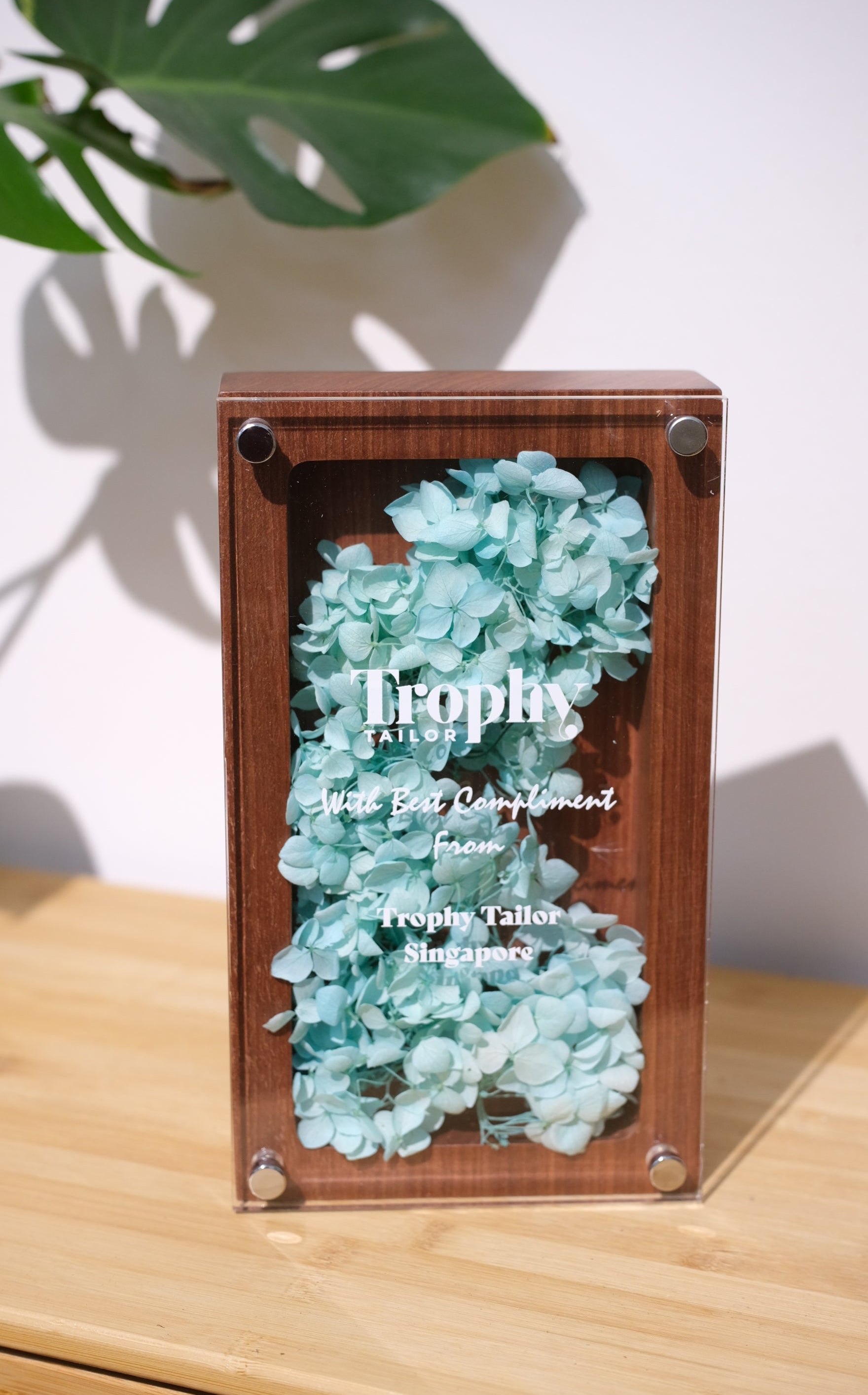 Wooden trophy with light blue preserved flowers