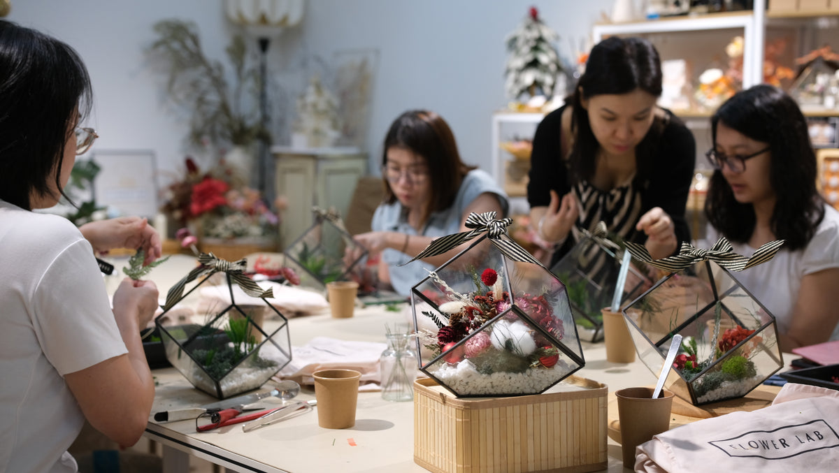 Participants making Christmas arrangements around the studio table