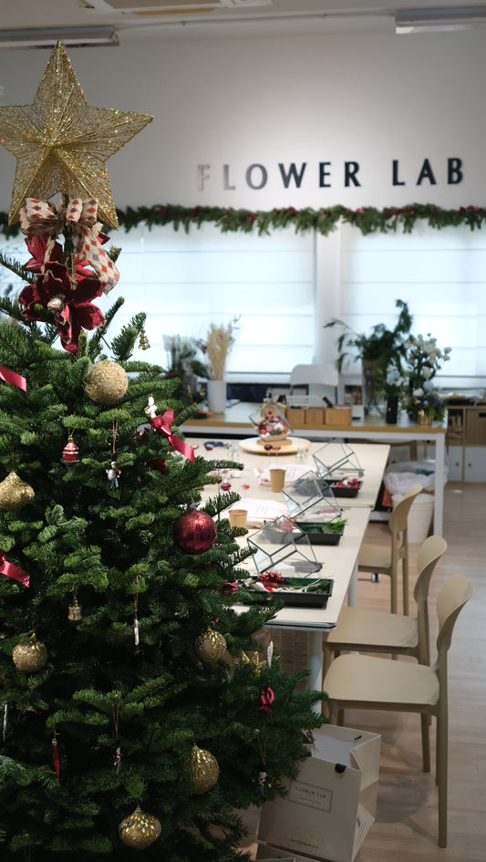 Flower Lab studio with a decorated Christmas tree and workshop tables set for guests