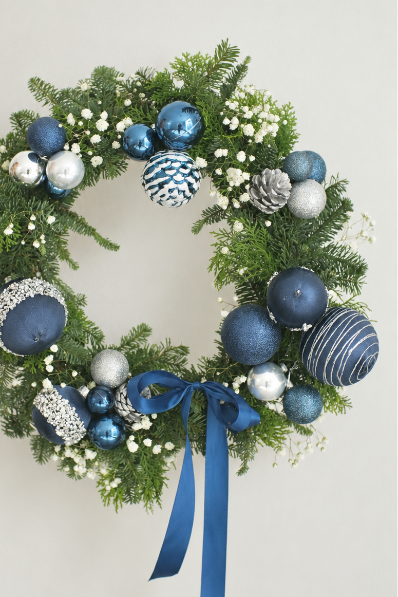 Fresh blue and silver Christmas wreath with baby's breath, silver pinecones and a navy satin bow